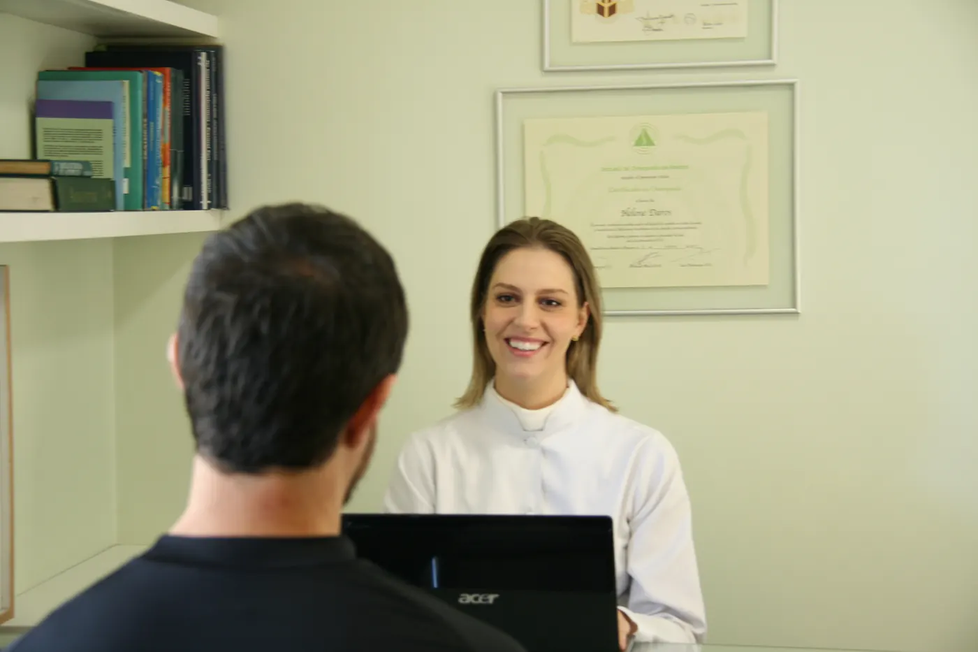 Helene conversando com um paciente no consultório